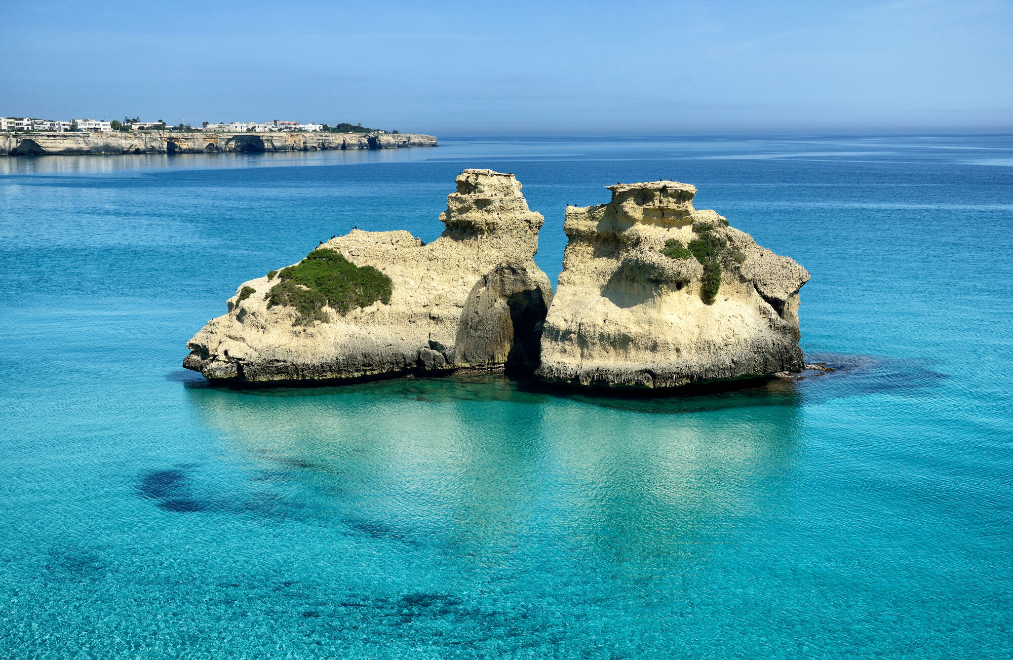 La splendida baia di Torre dell'Orso a Melendugno, nel Salento, vanta la Bandiera Blu e le 5 Vele di Legambiente. La spiaggia di sabbia bianca e finissima è incorniciata da una scogliera e una pineta, ed è bagnata da un'acqua cristallina. Le Due Sorelle, due scogli isolati, sono diventate un'immagine iconica del Salento. Lungo la scogliera si trovano anche numerose grotte con graffiti e testimonianze preistoriche.